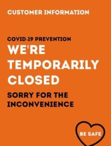 COVID-19 prevention notice announcing temporary closure of a business. The sign is in bold white text on an orange background, stating 'We're Temporarily Closed' with an apology for the inconvenience. A black heart icon with the words 'Be Safe' is at the bottom right.