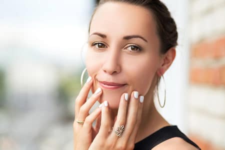 Confident and youthful woman with glowing skin, symbolizing the rejuvenating effects of facial and skincare treatments offered at Happy Head Massage in San Diego.